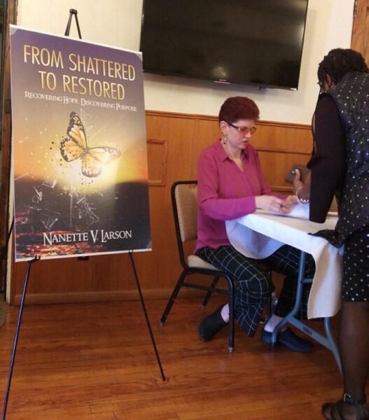 Nanette V. Larson signing her book From Shattered to Restored